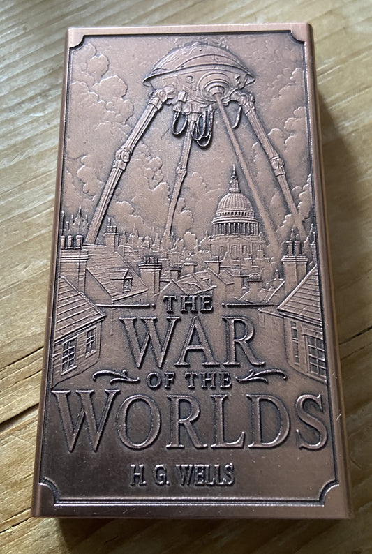 A rectangular bronze-colored book or box cover titled "The War of the Worlds" by H. G.